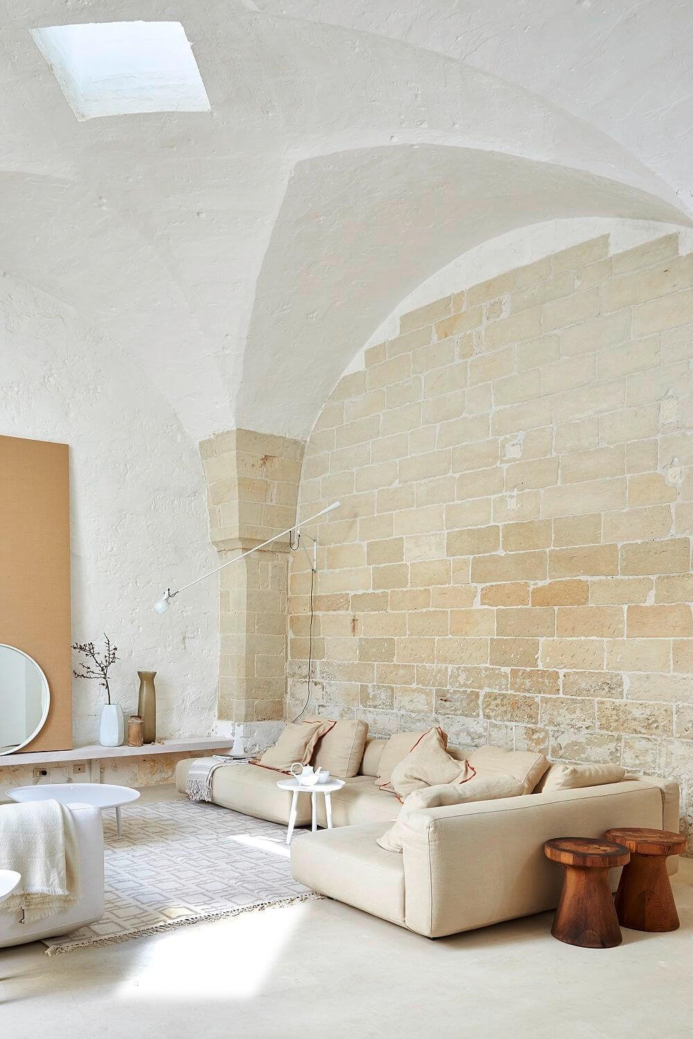 Revestimientos de piedra y taburetes de madera acompañan a cómodos sofás y lámparas de diseño. 