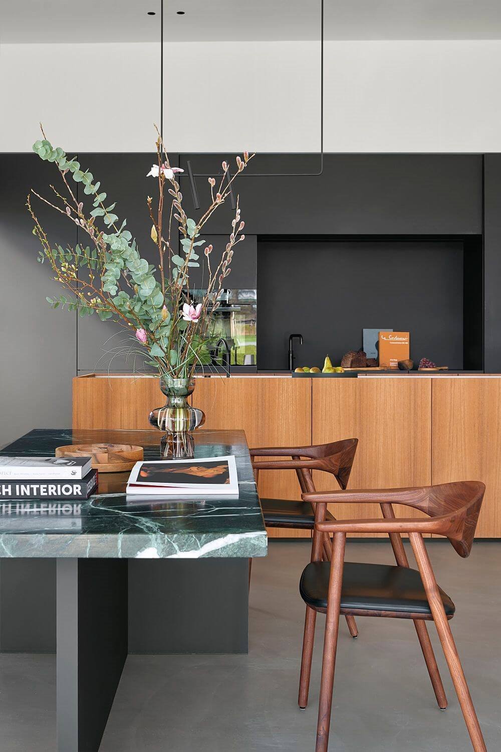 Decantarte por una mesa con sobre de mármol y sillas oscuras de madera impregnará de elegancia el conjunto.