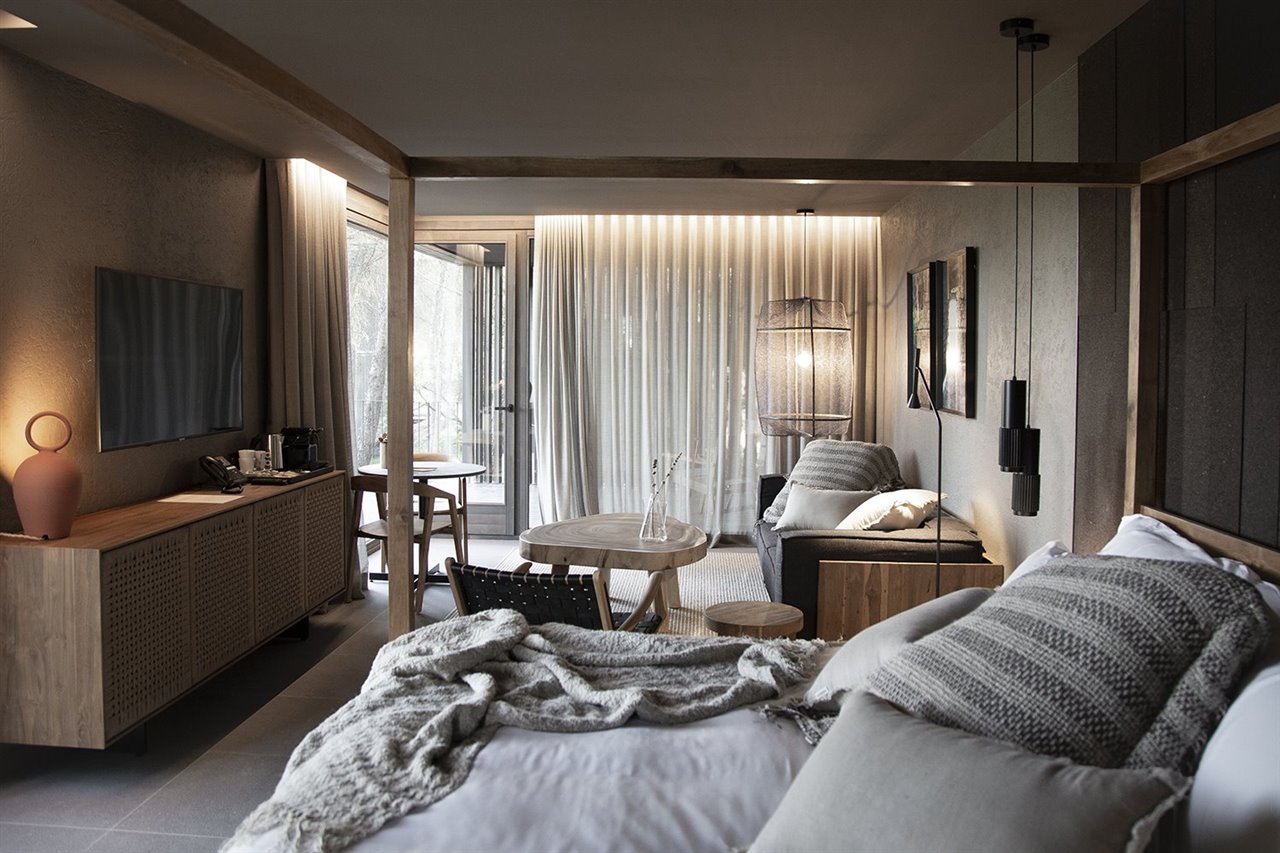 La madera natural maciza y los tejidos de fibras naturales predominan en el mobiliario y en las piezas decorativas, en coherencia con el carácter natural de todo el proyecto.