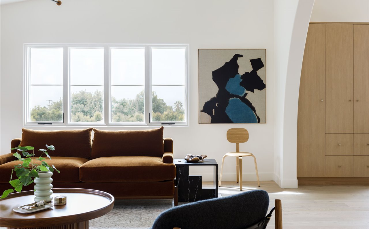 Casa moderna con arcos en Australia salon con sofa marron y cuadros