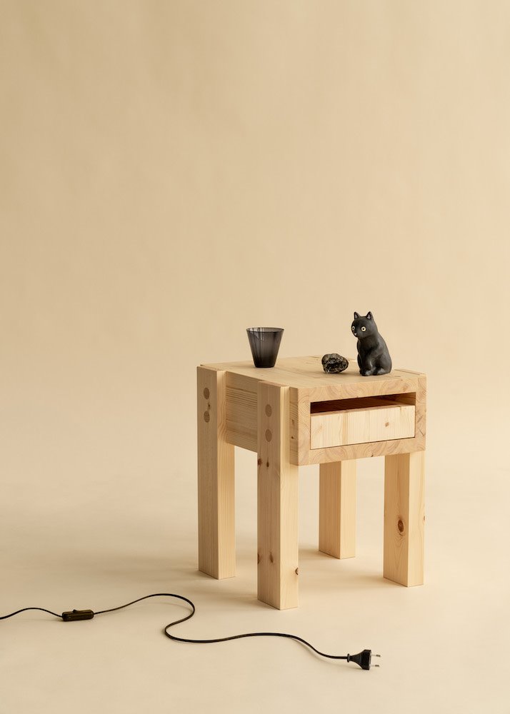 Mesita auxiliar con cajón Stilts, diseño de Philippe Malouin para Vaarnii, en madera de pino sin tratar.