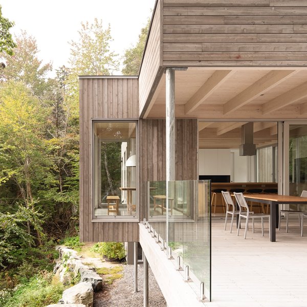 Una minimalista casa de madera elevada en mitad del bosque