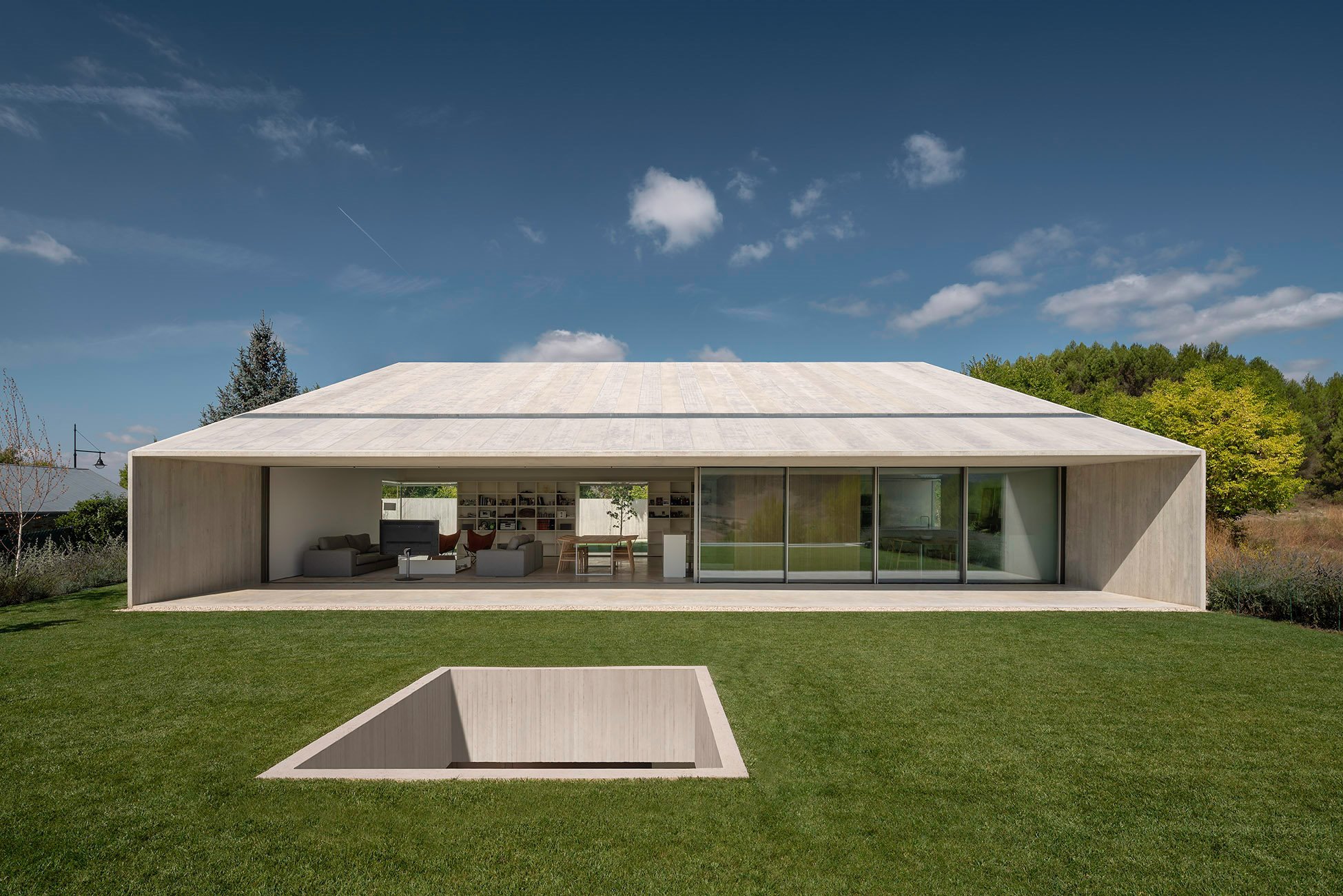 salón y cocina con césped casa hormigón