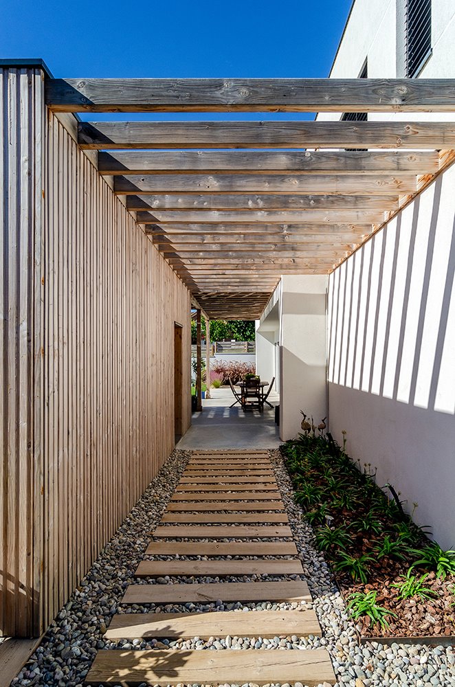 Al sur de la parcela se ubica un volumen auxiliar que aloja el garaje y el cuarto de instalaciones, y que se vincula a la vivienda visualmente a través de una pérgola.