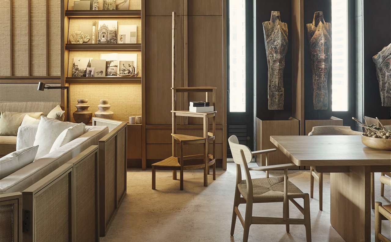 En el salón, rodeada de sillones tapizados con lino de Christian Liaigre, se alza una espectacular librería de madera, combinada con paneles de ratán, que mide más de seis metros de altura y contiene una colección de obras y libros de arte de los dueños de la casa.