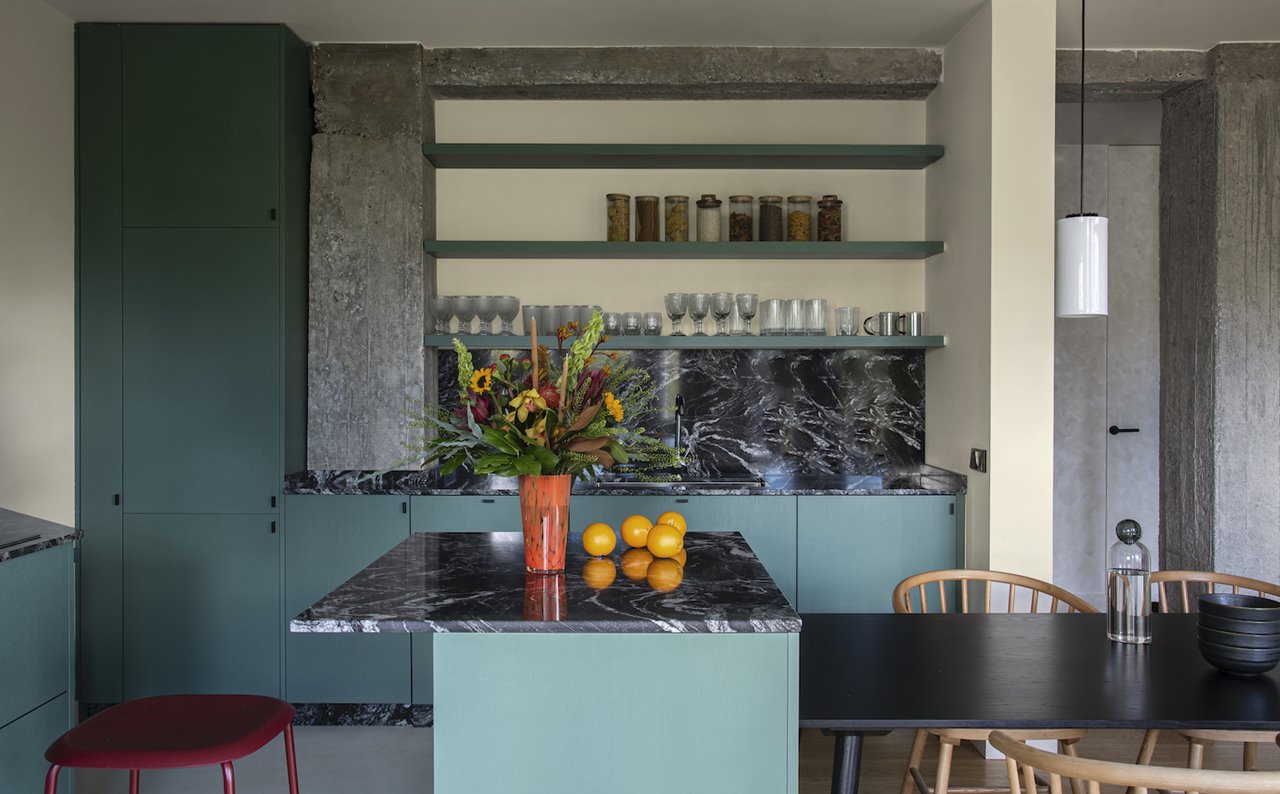 La cocina, diseñada a medida, ofrece zonas de trabajo amplias y un gran espacio de almacenamiento, con estanterías integradas