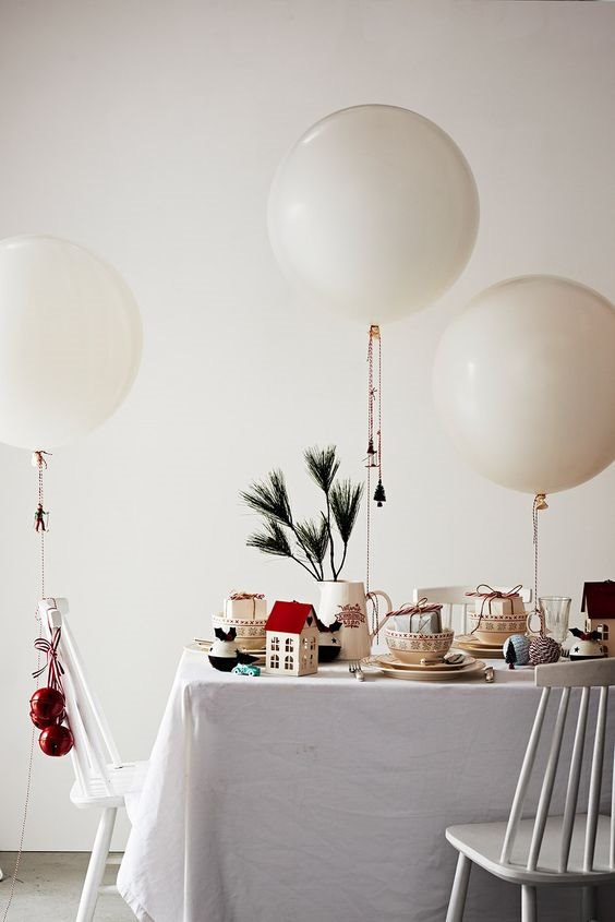 Mesa de Navidad decorada con globos y adornos del arbol navideño