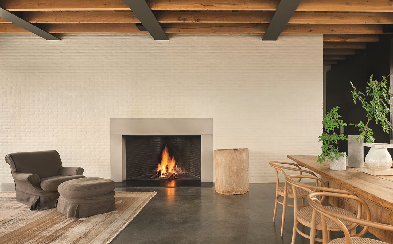 El espacio se percibe despejado: pocos muebles, pero todos de buen diseño. La butaca y el puf proceden de la prestigiosa tienda belga de antigüedades de Axel Vervoordt. Junto a la chimenea, un objeto de madera, de Rose Uniacke. Las sillas son las Bentwood, de Thonet (1900).
