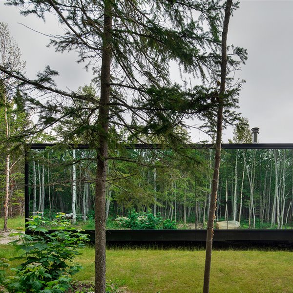 Esta casa prefabricada de madera y cristal desaparece entre los árboles