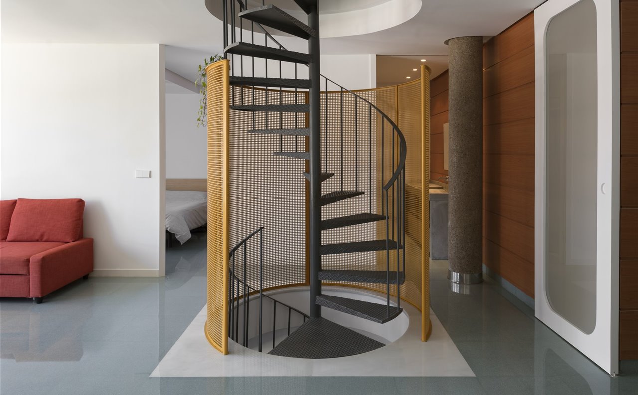 De ser un elemento aislado, la escalera de caracol ha pasado a ser la estrella central de esta vivienda estudio en Valencia.