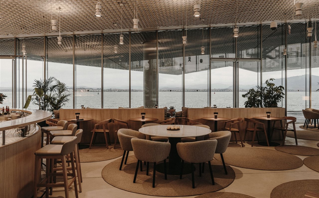 Las fachadas acristaladas abren los espacios flexibles de la reformada cafetería del Centro de Arte Botín, en Santander, con vistas a la bahía. El proyecto ha logrado dinamizar los recorridos y crear un espacio gastronómico acogedor.