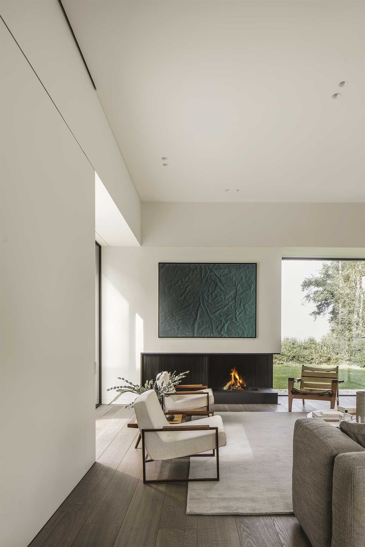 Los muebles brasileños vintage introducen en el salón de esta casaen Bélgica del estudio Nicolas Schuybroek Architects piezas icónicas que rompen con el esquema tradicional.