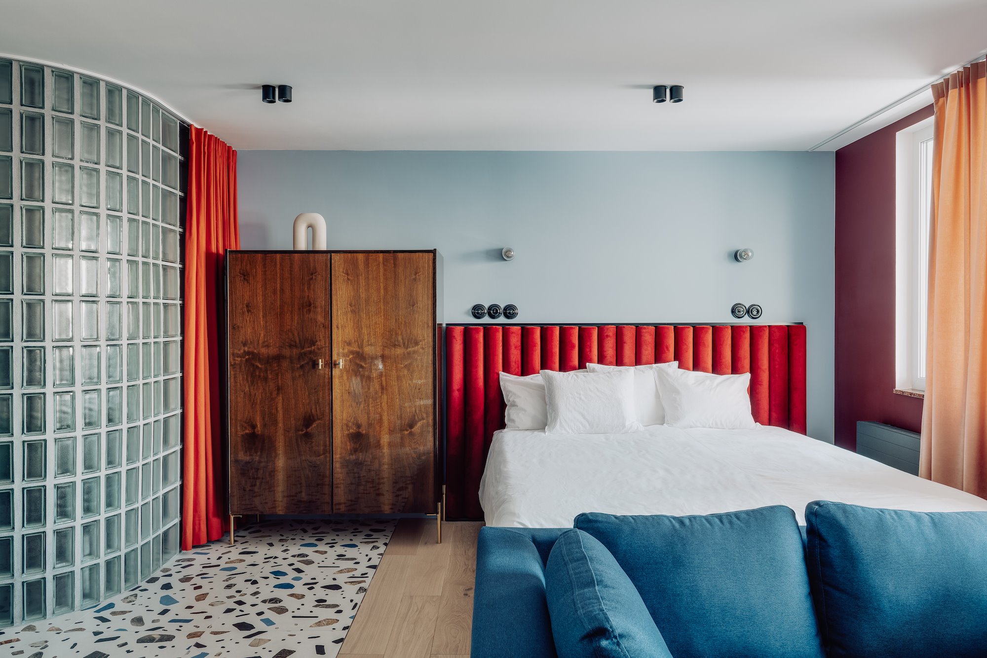 Dormitorio con cabecero rojo y mueble vintage.