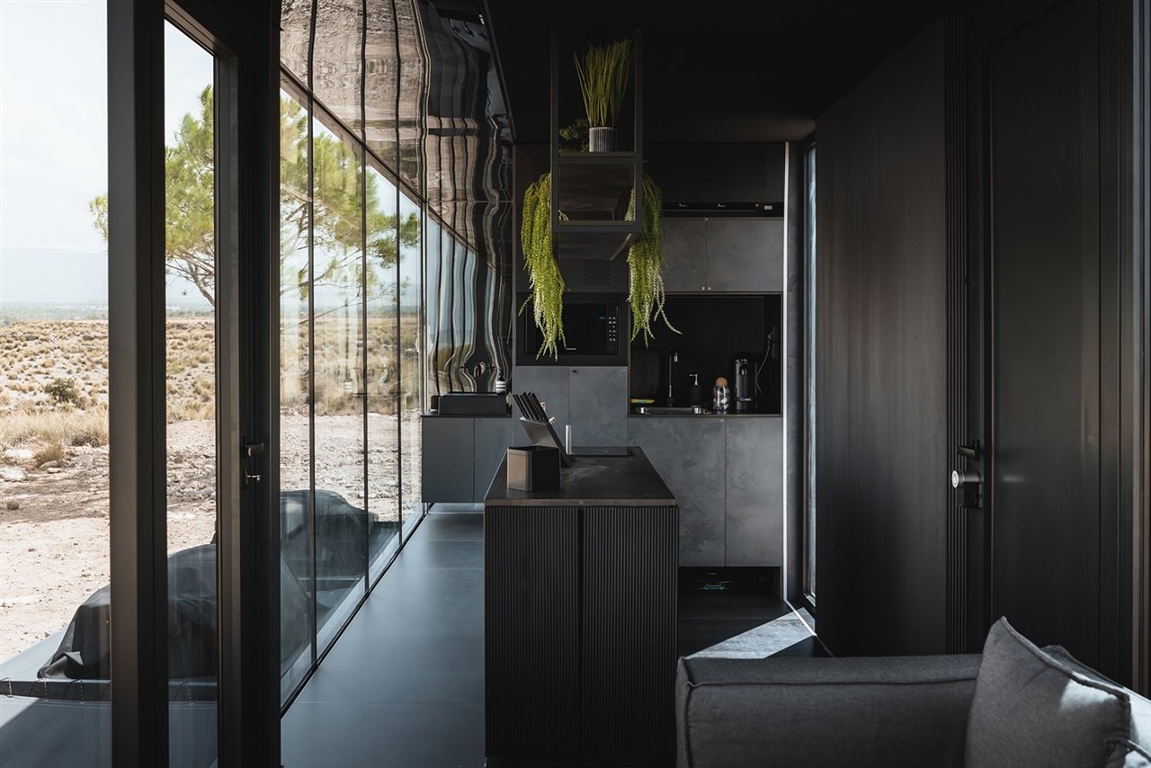 Su interior está equipado con un cuarto de baño, una cocina-estar-comedor, un dormitorio con cama doble y dos individuales ocultas, armarios modulares multifuncionales y estanterías.