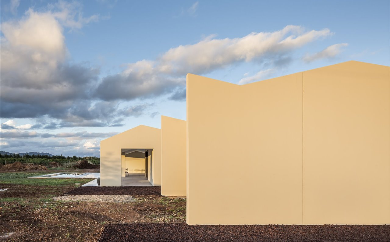 En esta vivienda construida con paredes de hormigón prefabricadas, el estudio Ubiko ha apostado por la vinculación de su arquitectura con el territorio en el que se encuentra. Así, su diseño permite conectarla con el exterior y se ha recubierto su fachada de cerámica típica de la zona.