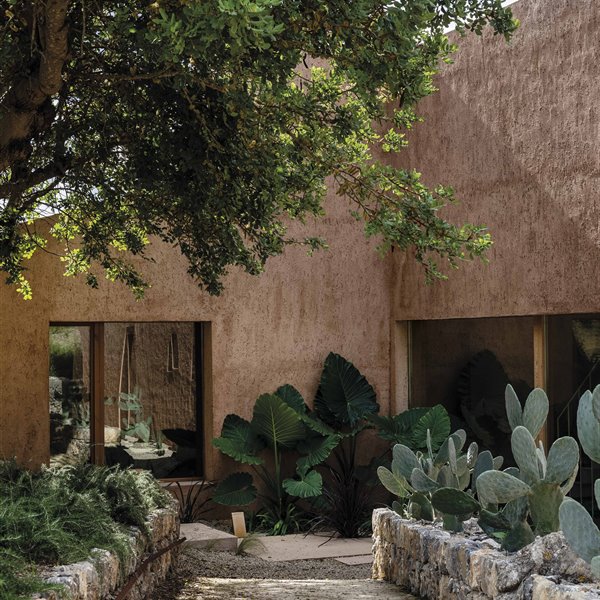 Una casa en Mallorca con muros rojizos que nacen de la tierra