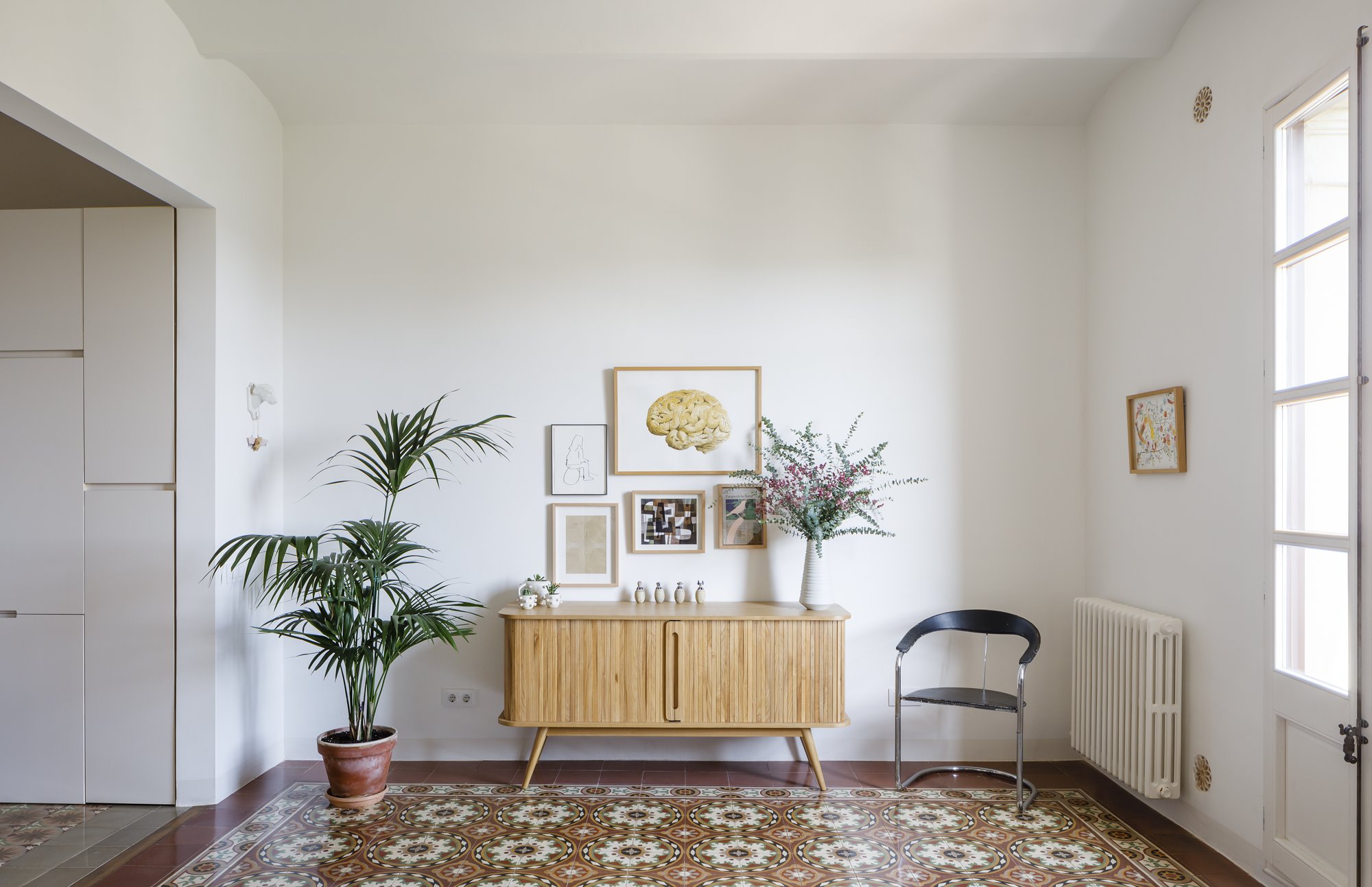 Salon con mueble de madera y silla de hierro  de un piso en Barcelona