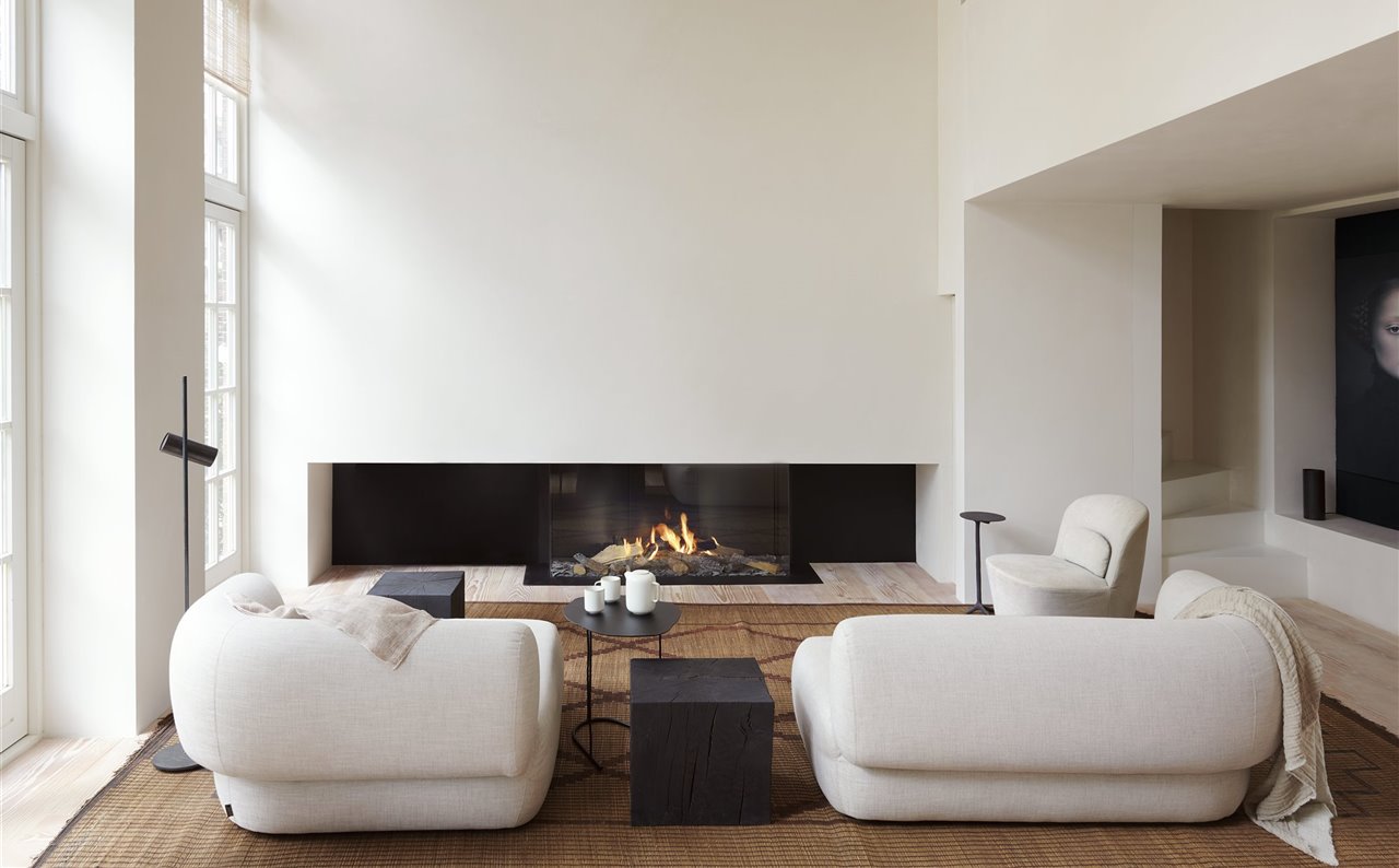 Los dos sillones, de gran tamaño para que armonicen con la amplitud y altura del espacio, son el modelo Arp, diseño de Sebastian Herkner para Linteloo.