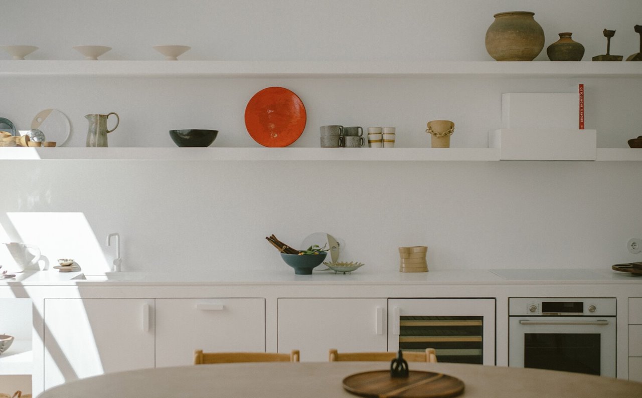 Cocina blanca con estantería de obra en Casa Dois en Portugal