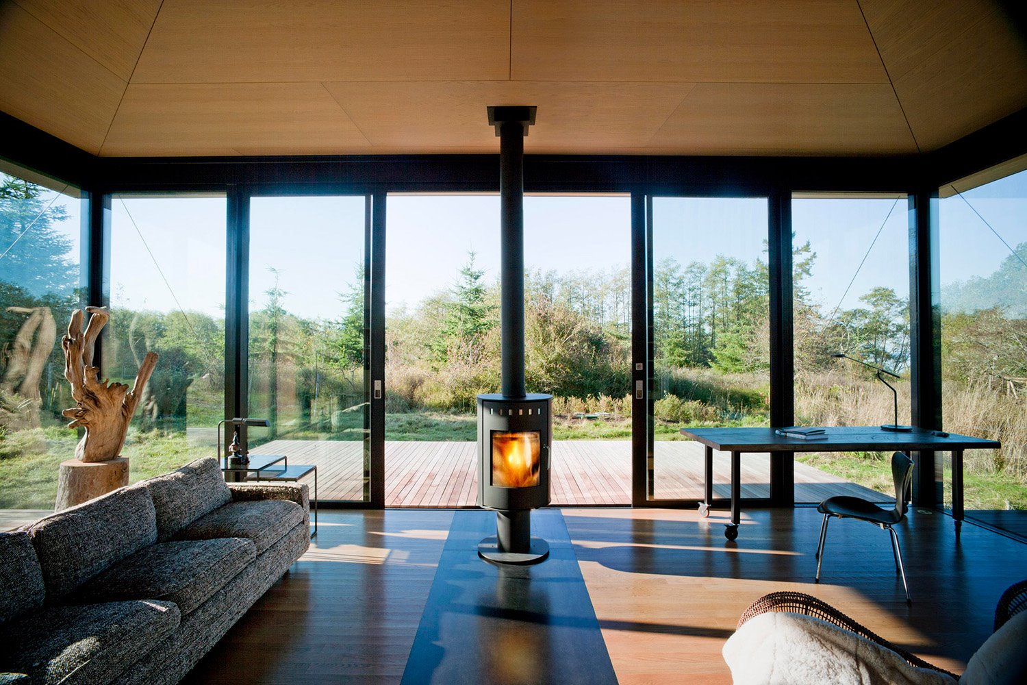 Una chimenea de hierro cerrada preside el espacio diáfano. La chimenea puede rotar 180 grados para calentar tanto el interior como la terraza frontal.
