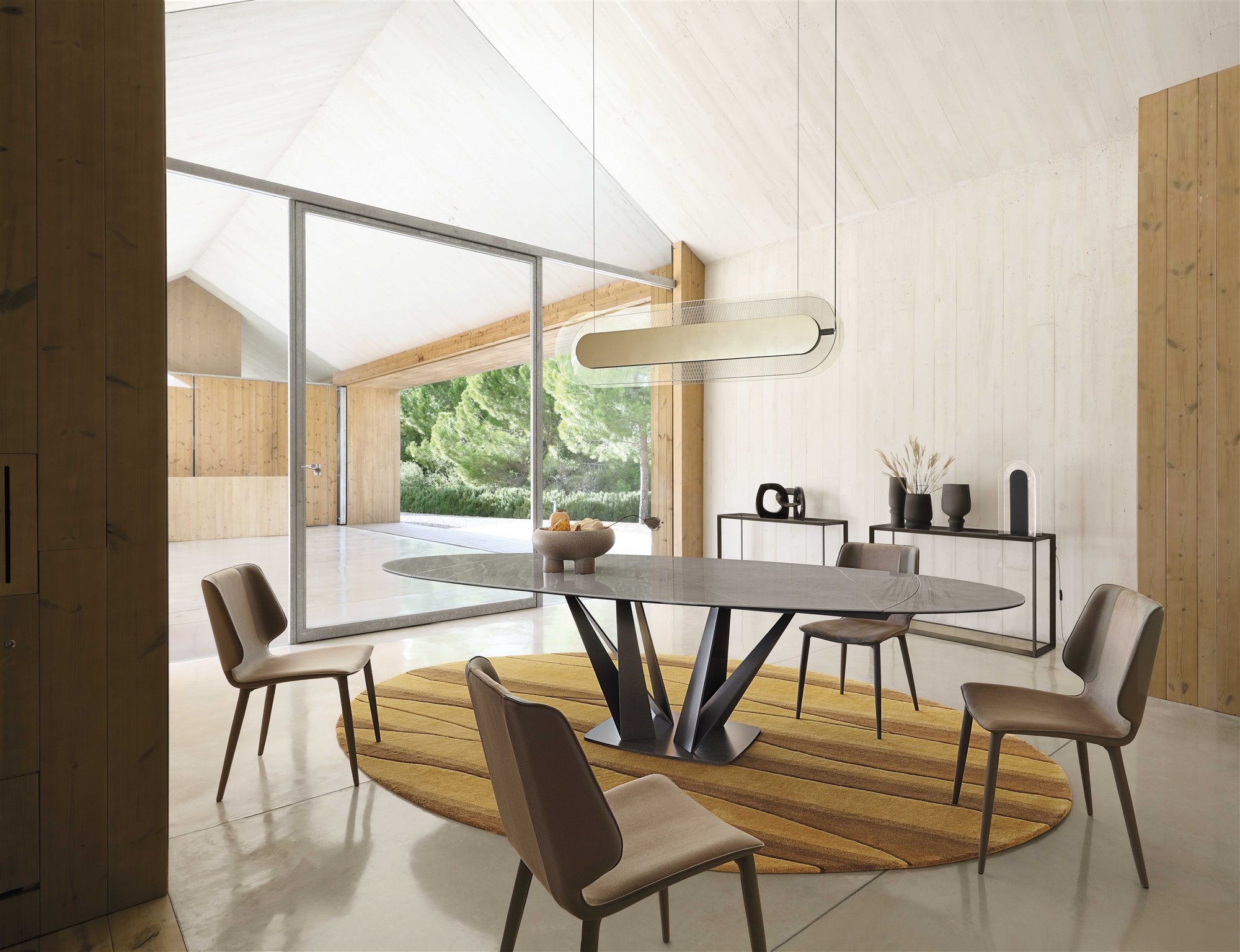 mesa de comedor ovalada con sillas y alfombra amarilla de roche bobois