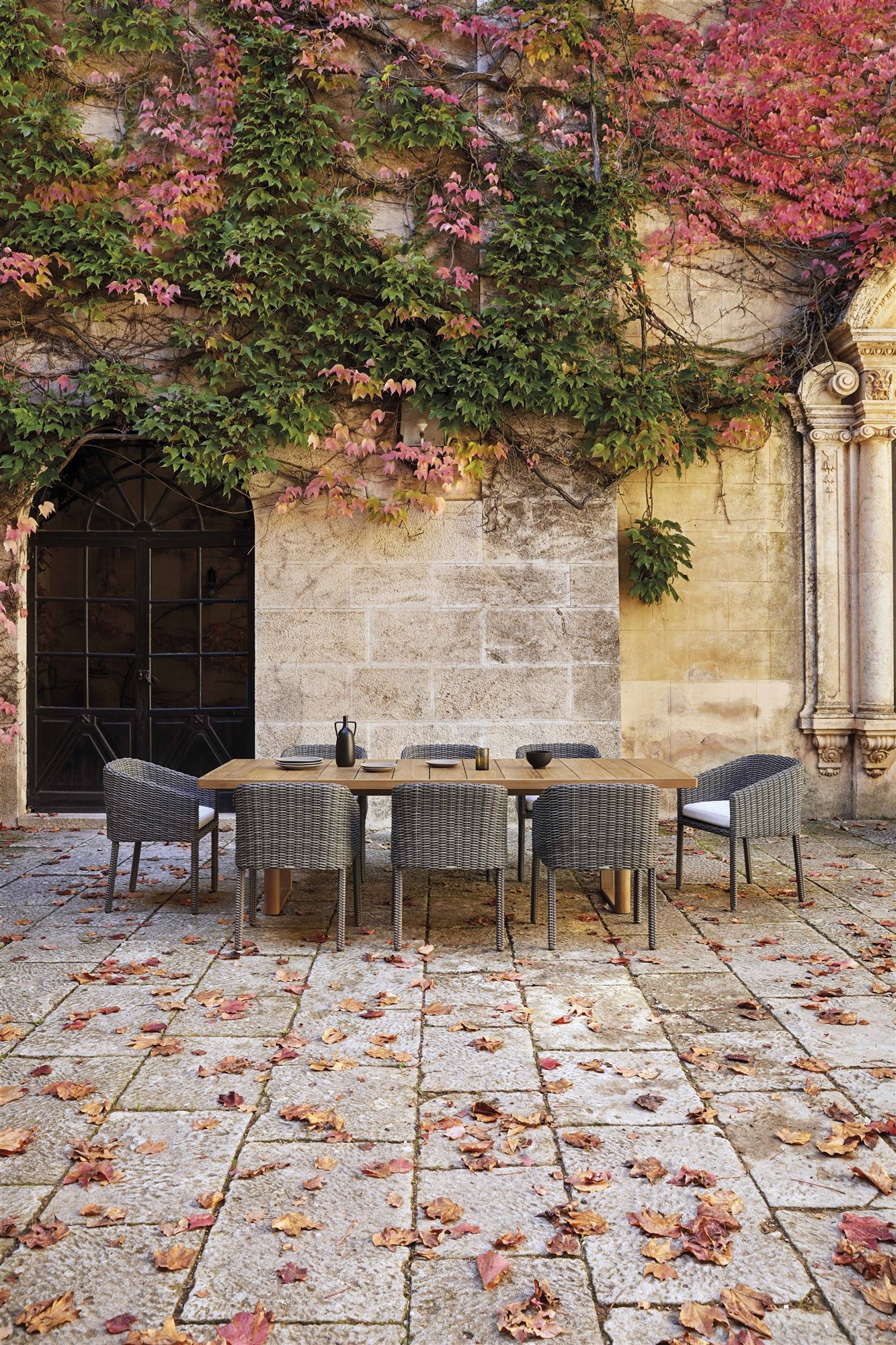 mesa de comedor y sillas de exterior en un patio con hojas de Point