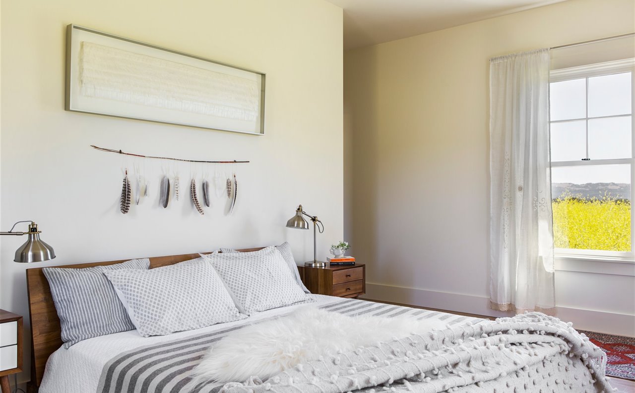 Los tonos neutros en las sábanas y la artesanía de la cama invitan al descanso