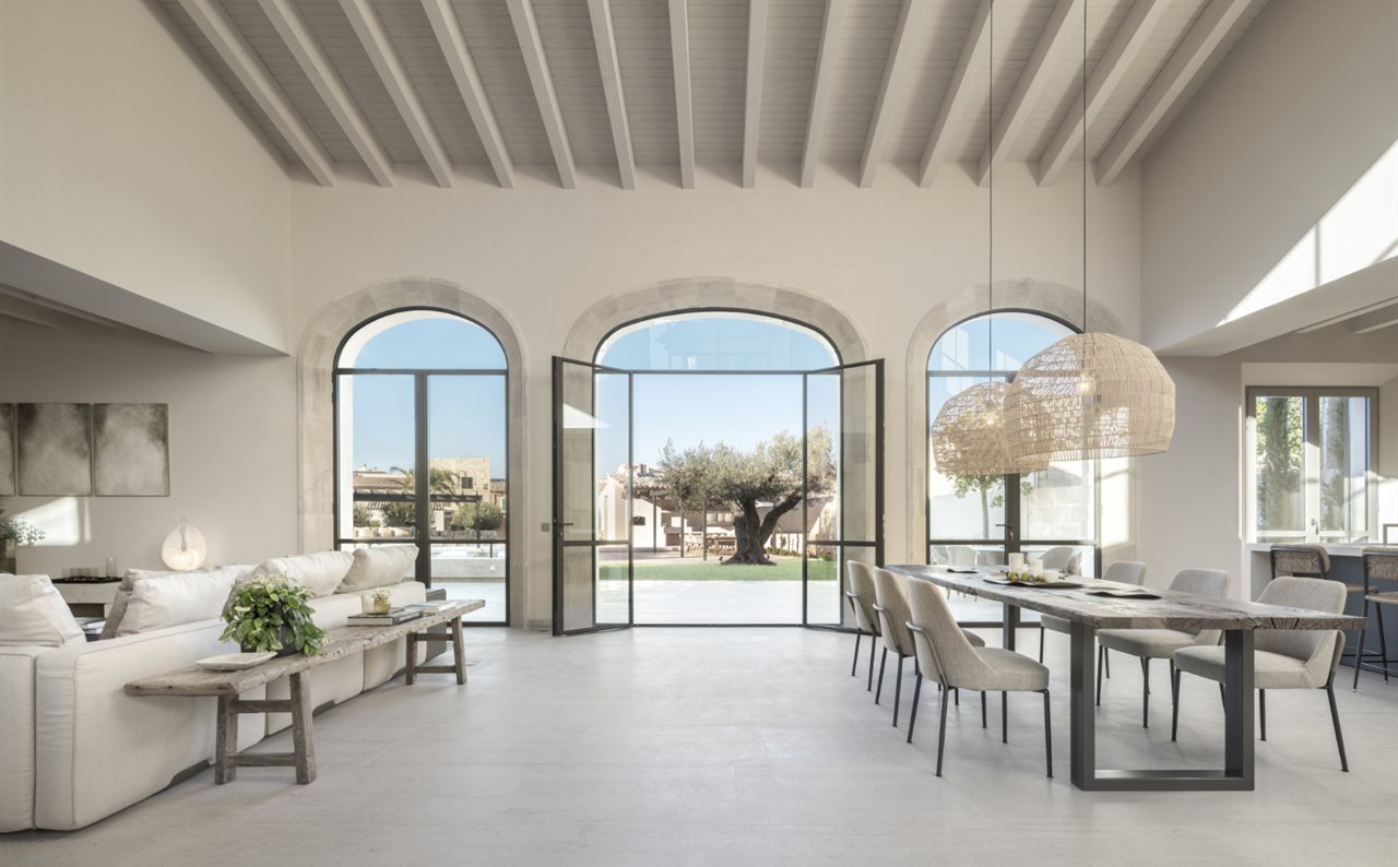 Respetando la arquitectura del espacio, el salón fluye suavemente hacia el comedor y la cocina. Sillas de comedor Joyce, de Flexform.