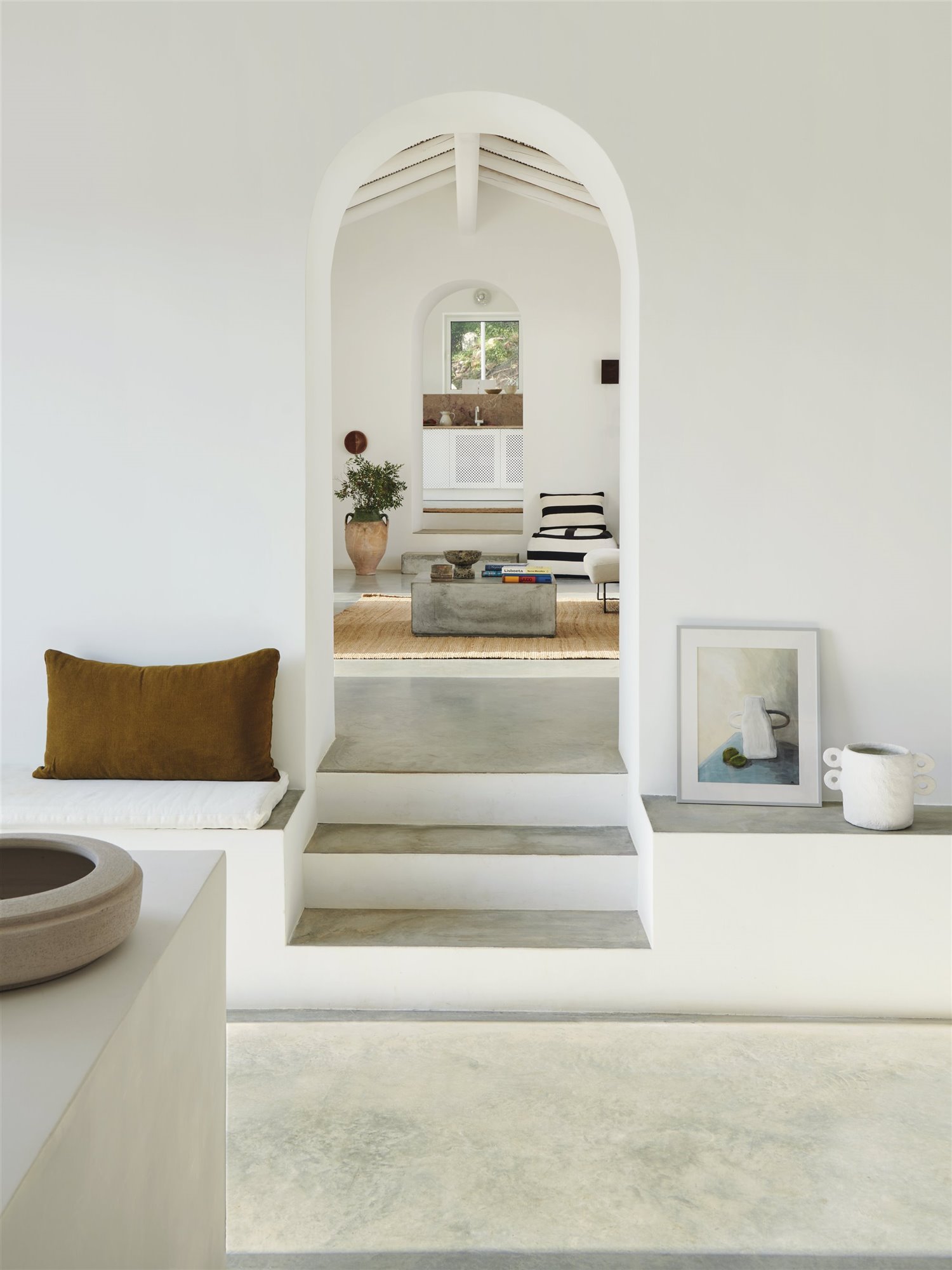 salón blanco con escaleras y arco 