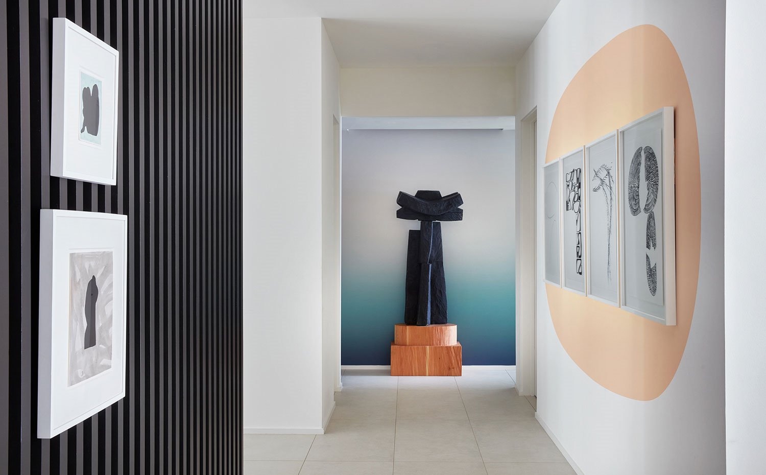 Zona de paso con escultura y pinturas enmarcadas sobre pared pintada o texturada
