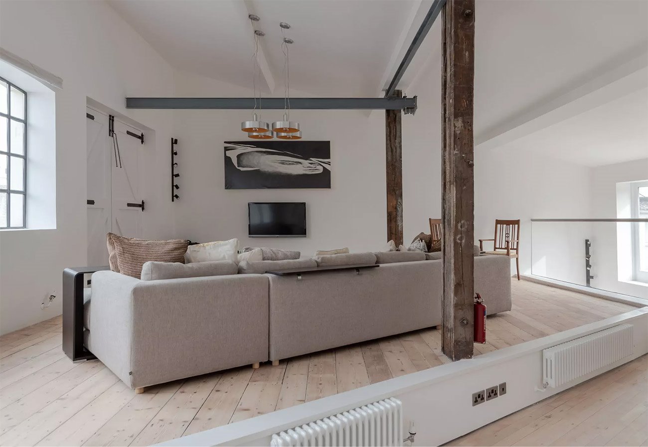 Antigua fabrica convertida en un loft moderno en londres salon con vigas de madera