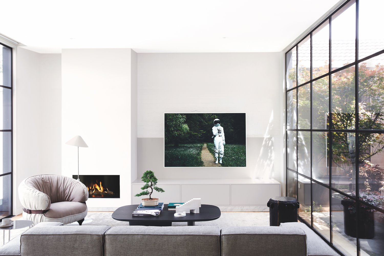 salon con sofas y sillon de color gris y chimenea
