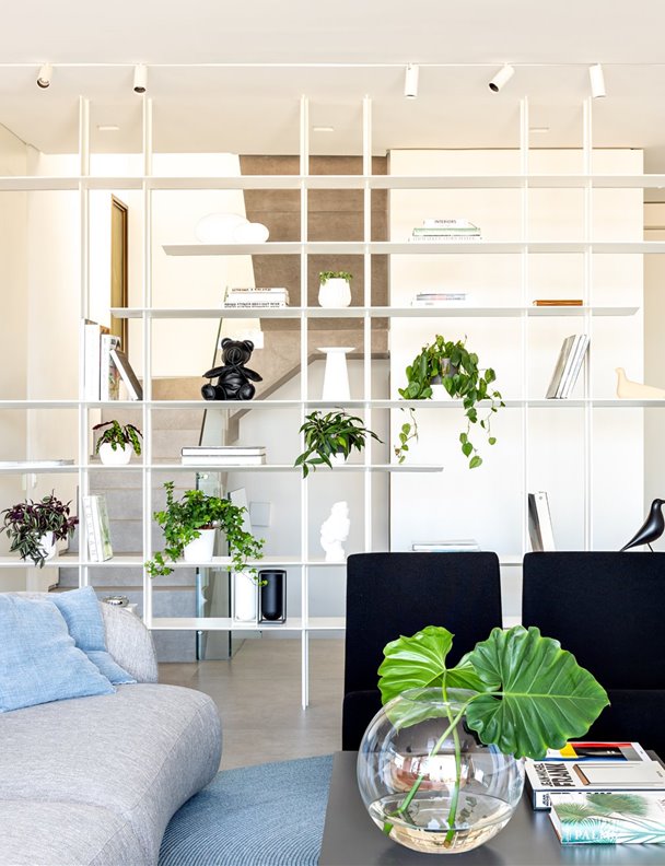 Una casa abierta al mundo con una moderna estantería que distribuye el espacio