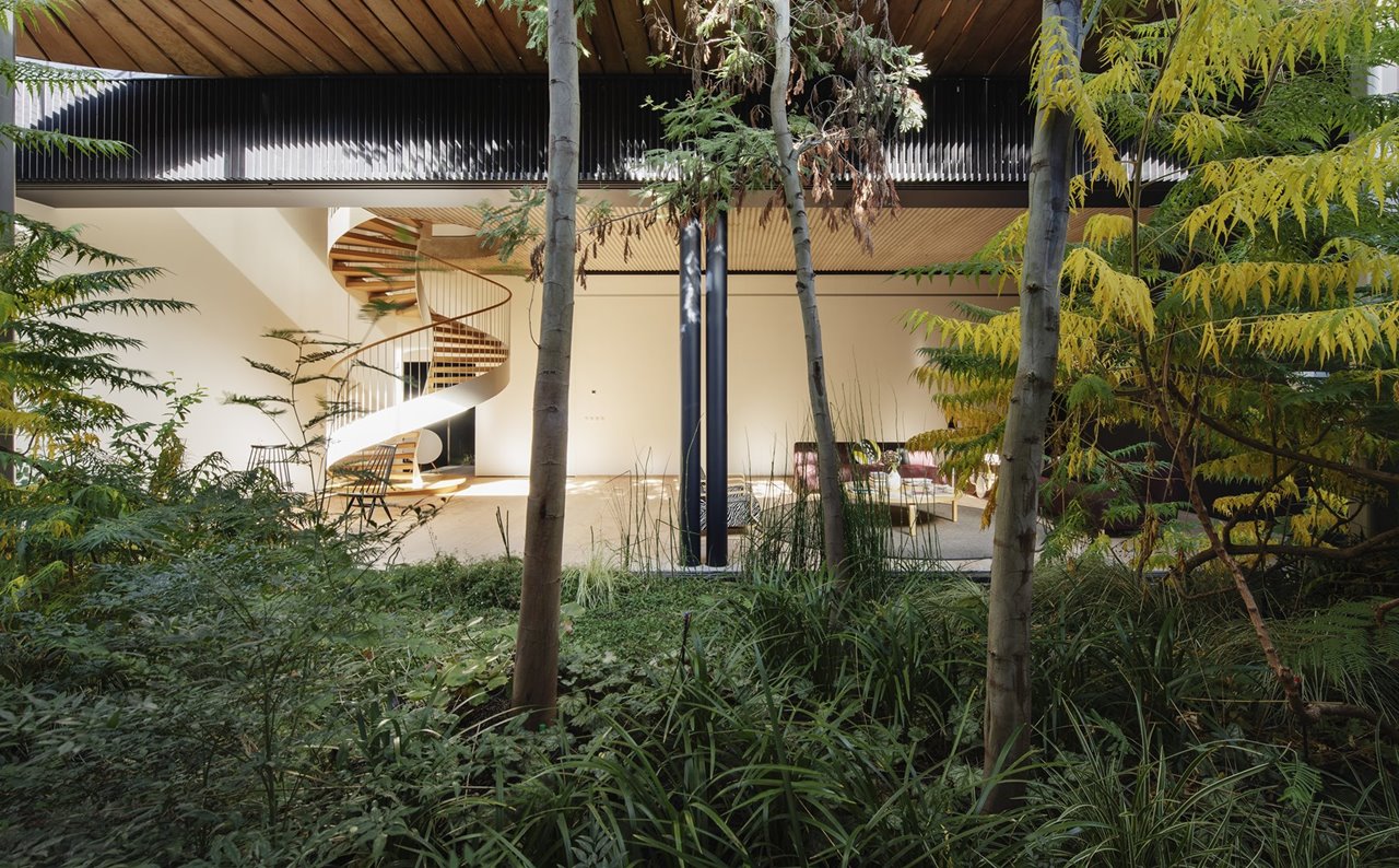  Un patio al aire libre con una exuberante vegetación sumerge a los residentes en un oasis verde privado.