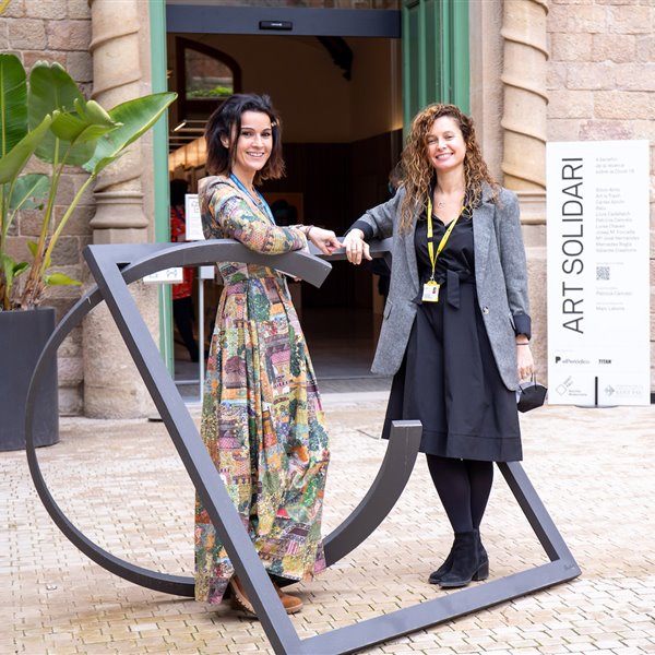 Patricia Cancelo –izquierda– junto a Elisa Llurba, directora de Ginecología y Obstetricia del hospital de Sant Pau, con una de las obras expuestas en la muestra Art Solidari en el Hospital de Sant Pau.