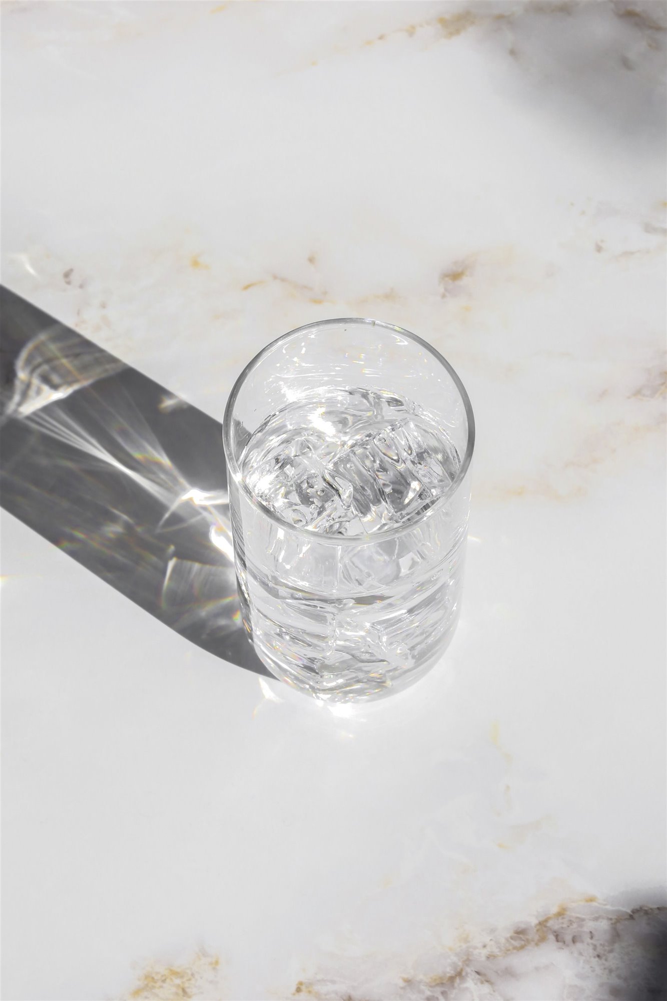 vaso de agua en una mesa blanca de mármol