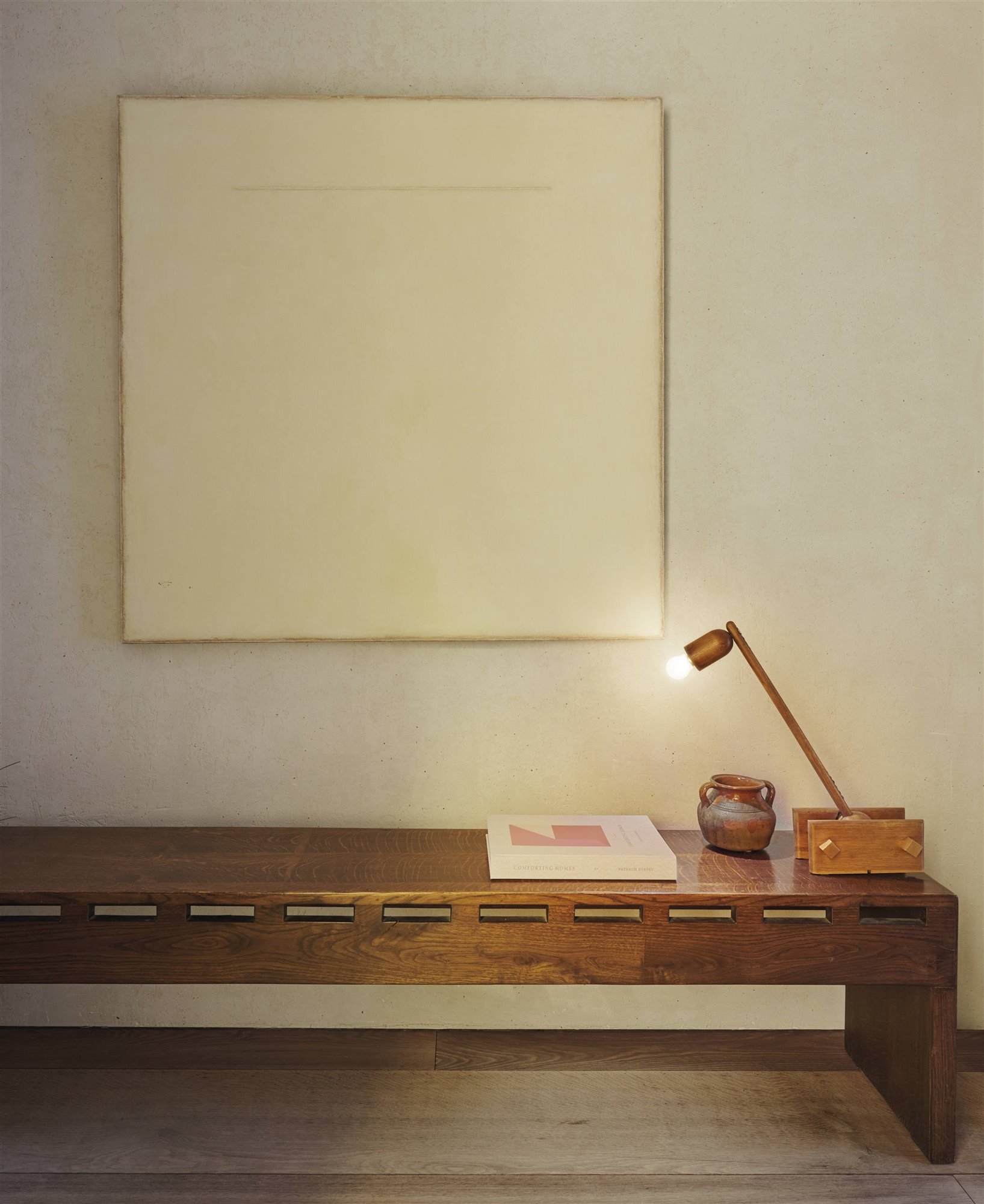banco de madera con lámpara retro y cuadro blanco