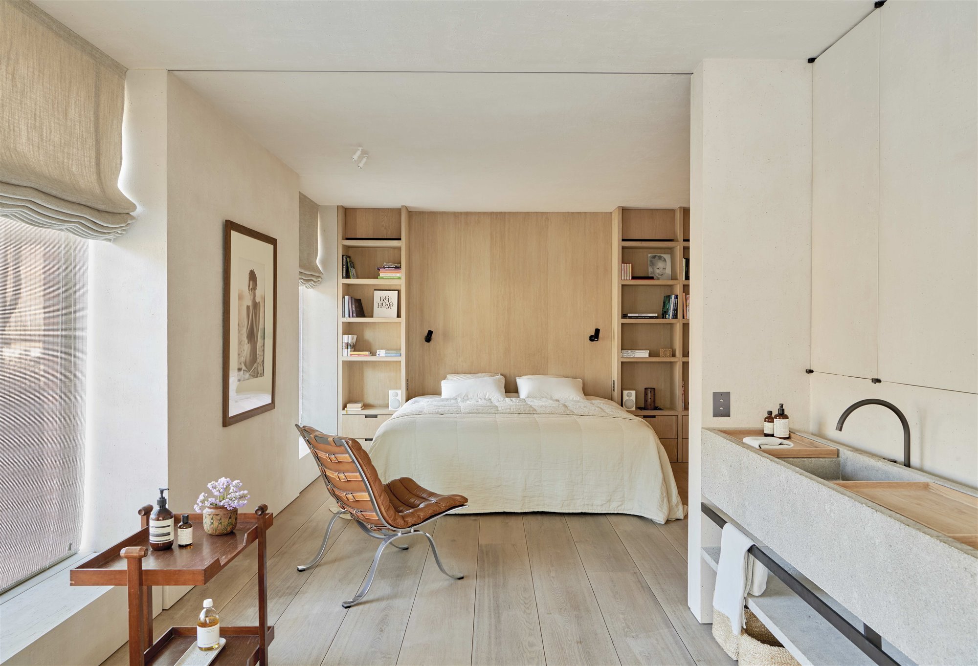 dormitorio de madera con butaca de piel y lavamanos