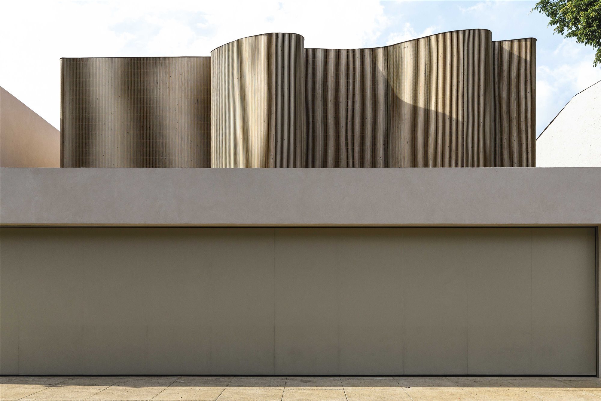 fachada ondulada de madera de arthur casas con muro