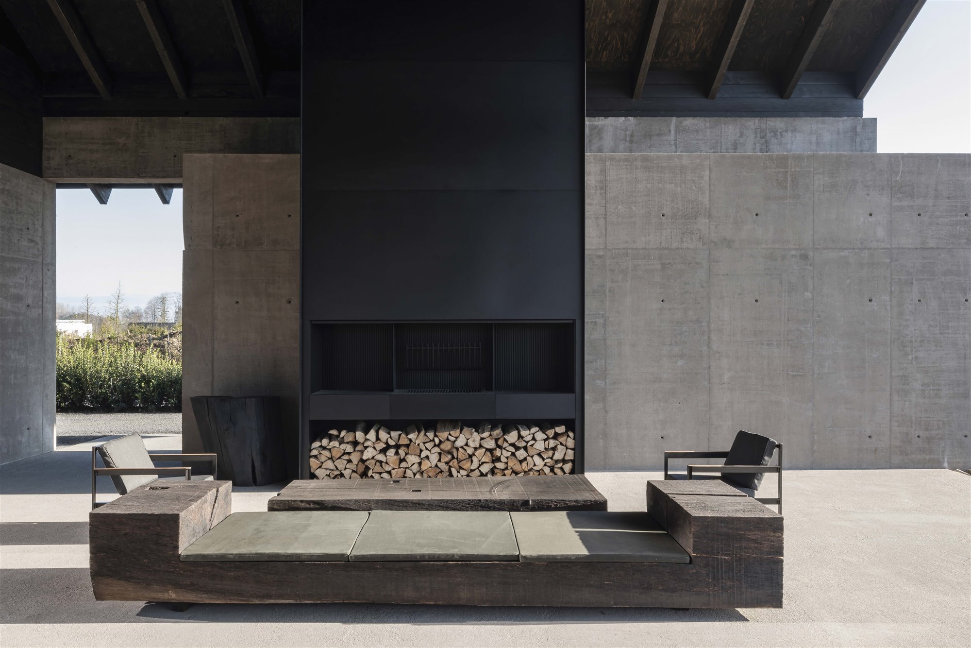patio de hormigón con chimeneas y butacas bodega Valke Vleug de Vincent Van Duysen