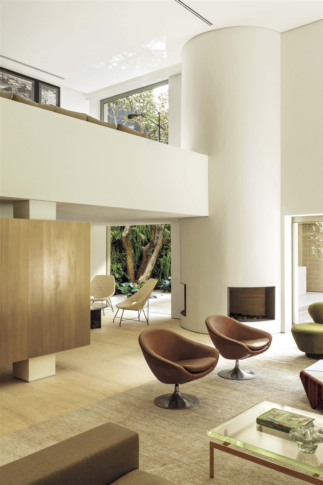 salón moderno con butacas y chimenea en columna de arthur casas