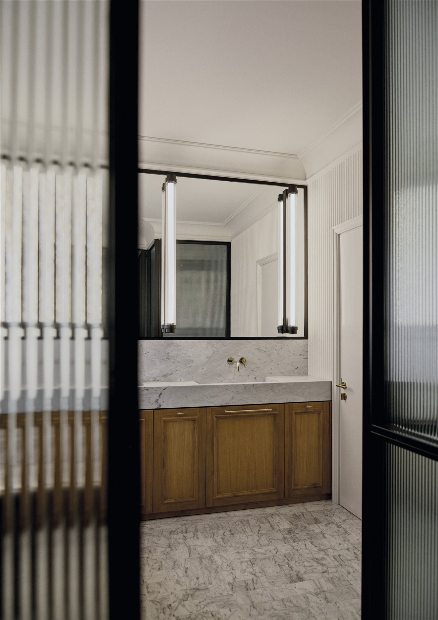 baño de mármol con mueble de madera