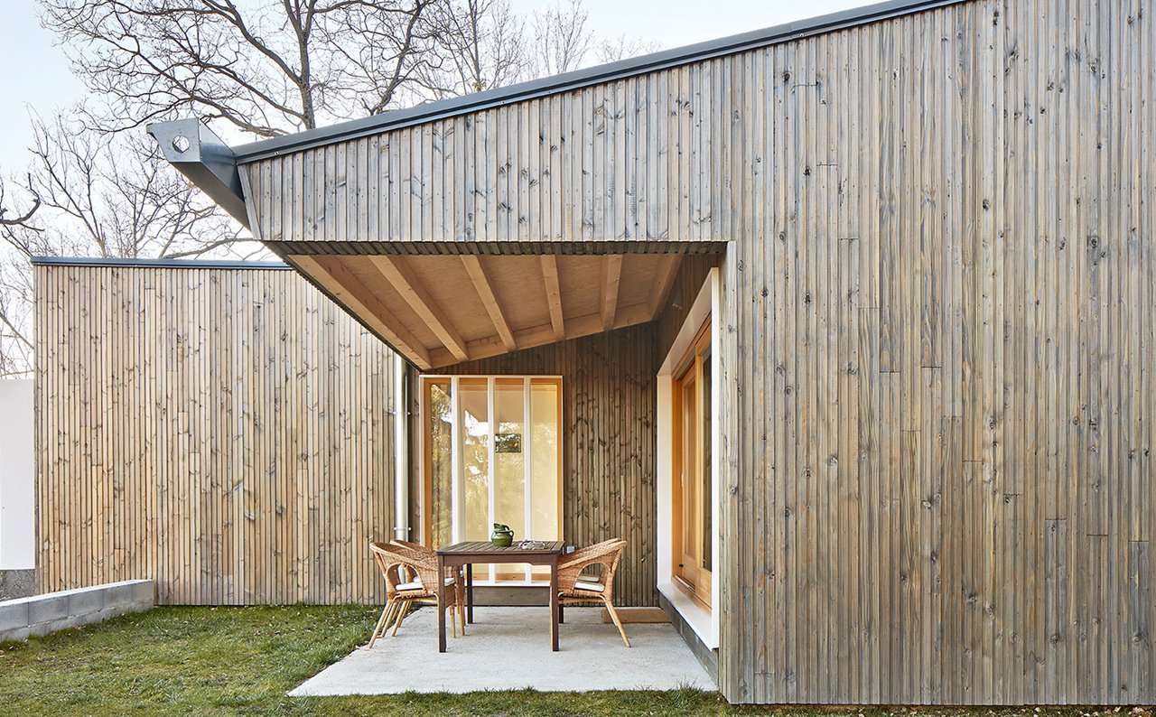 Una casa de madera de diseño moderno con piscina y porche