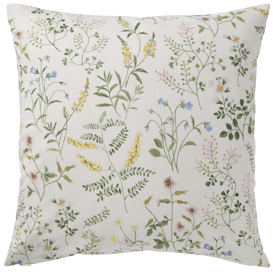cojín beige con estampado de flores verde amarillo azul y rosa