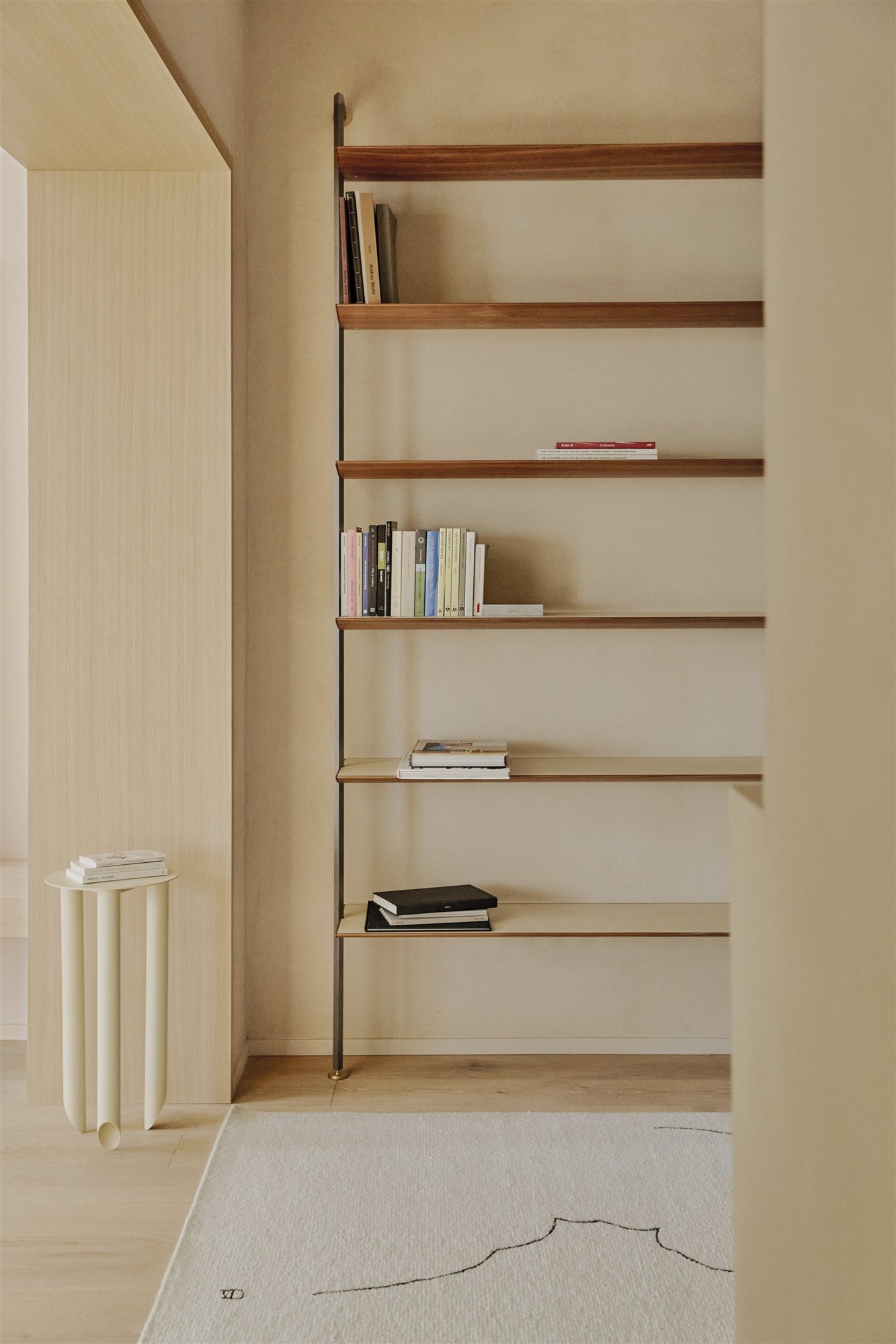 estantería de madera con libros y mesa blanca