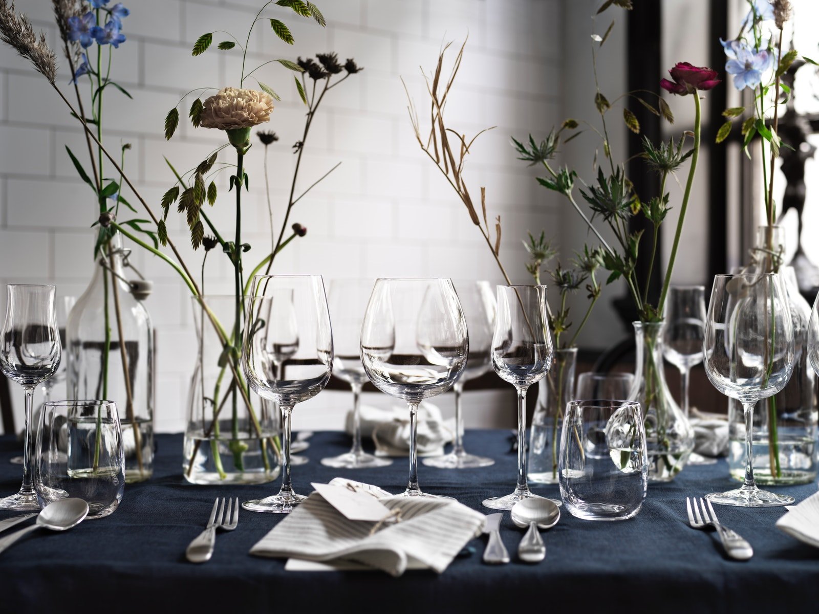 mesa de comedor con copas de cristal y flores