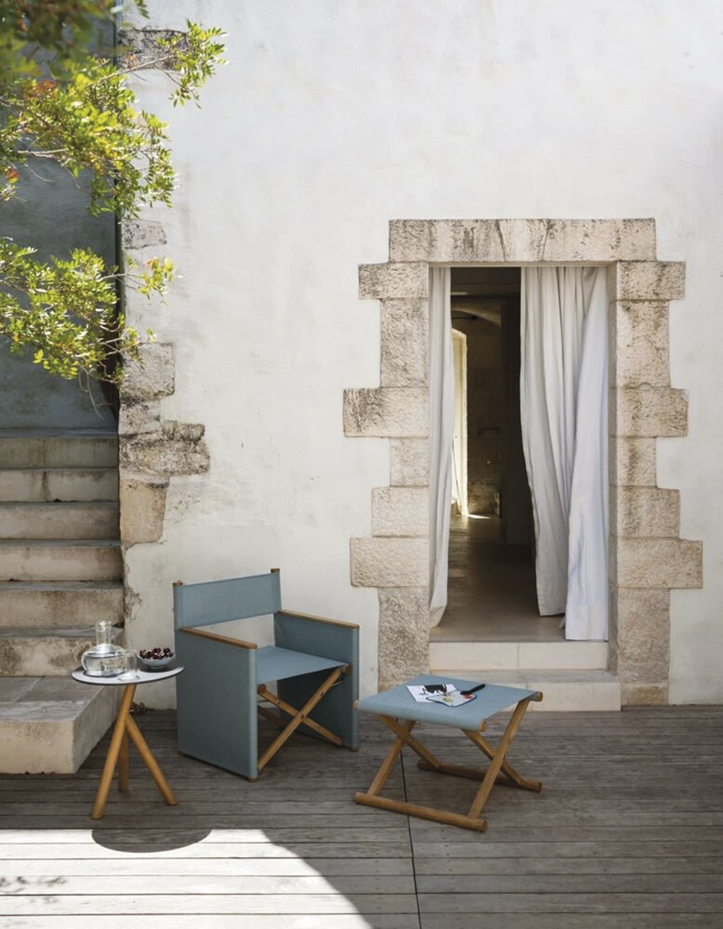 casa de piedra con patio de madera, silla de director y mesa azul