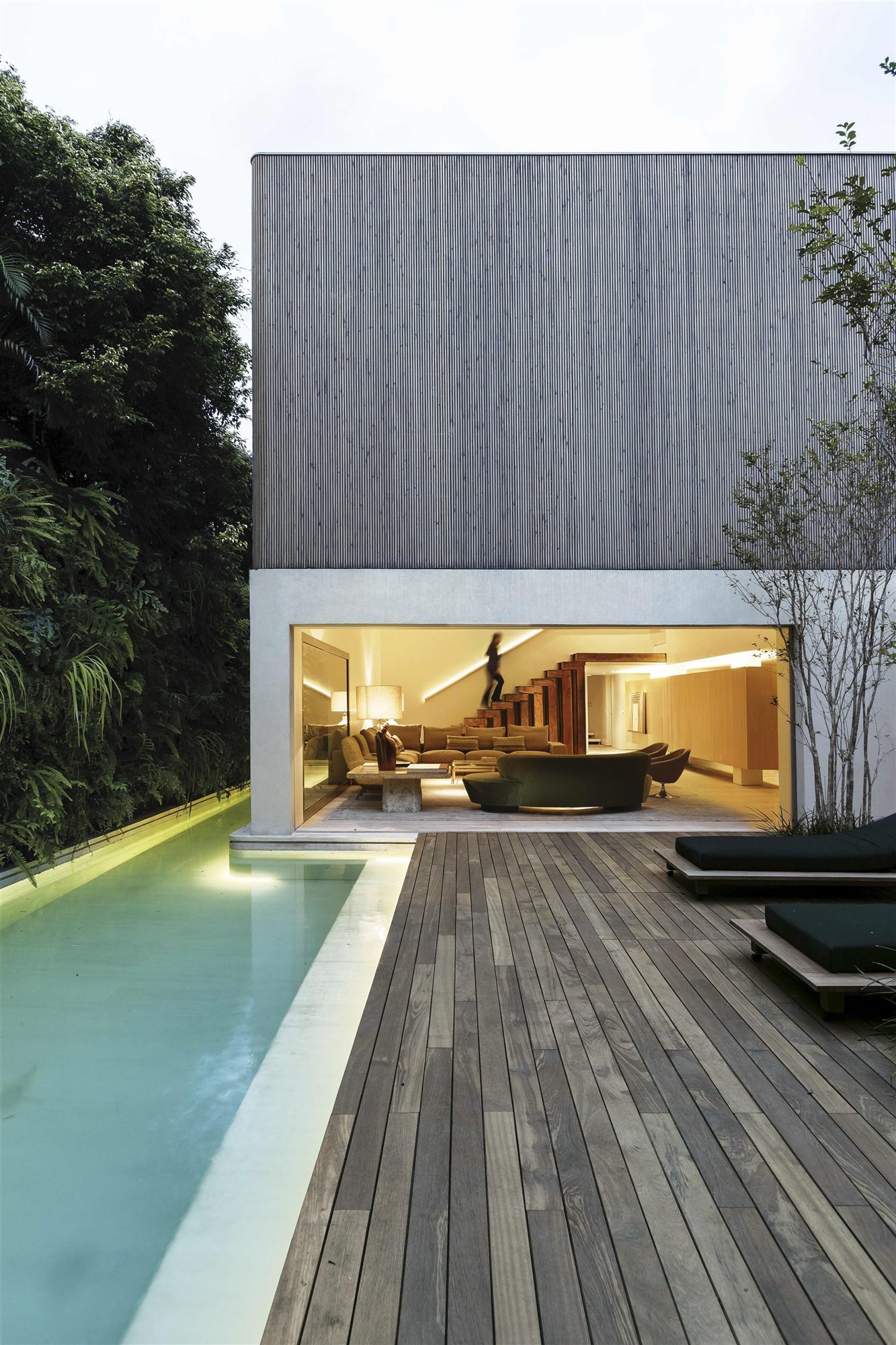 fachada de madera con piscina y tumbonas de arthur casas