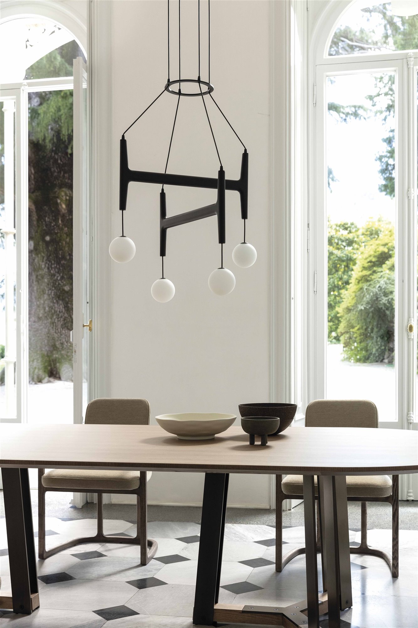 lámpara de techo negra brazos y esferas blancas, mesa de comedor con cuencos