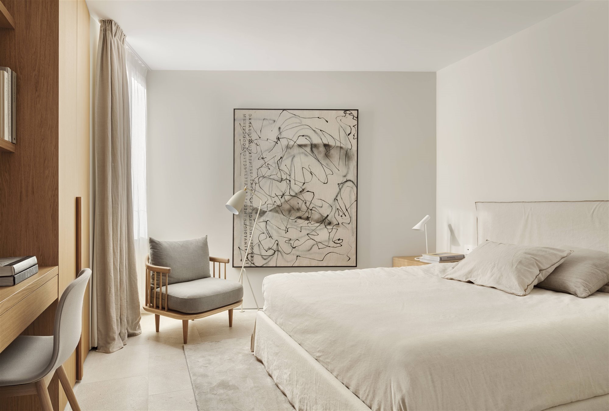 dormitorio con cama blanca, butaca de madera y gris, armario de madera, cuadro y lámparas